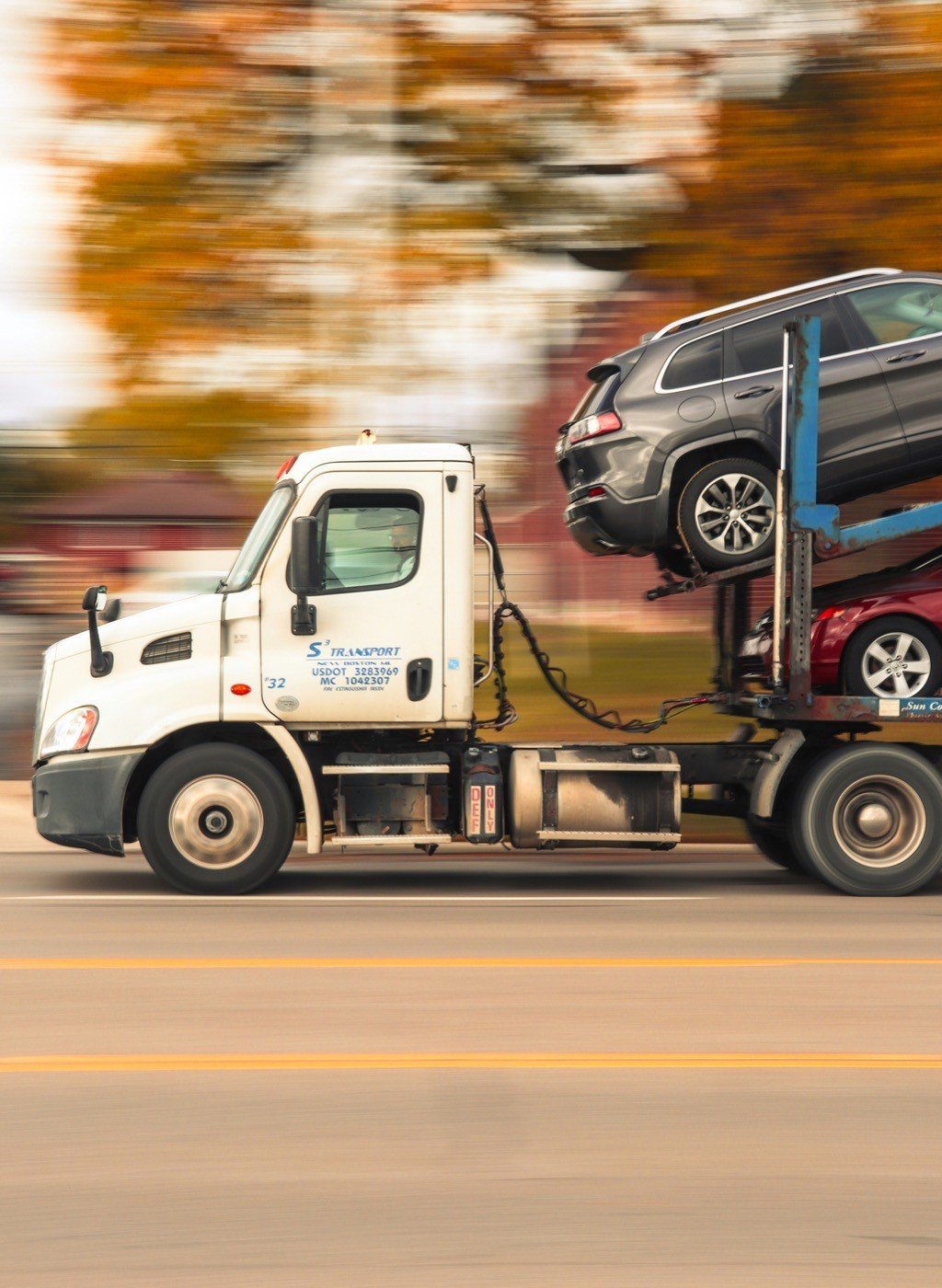 Car carrier truck loading a car and SUV